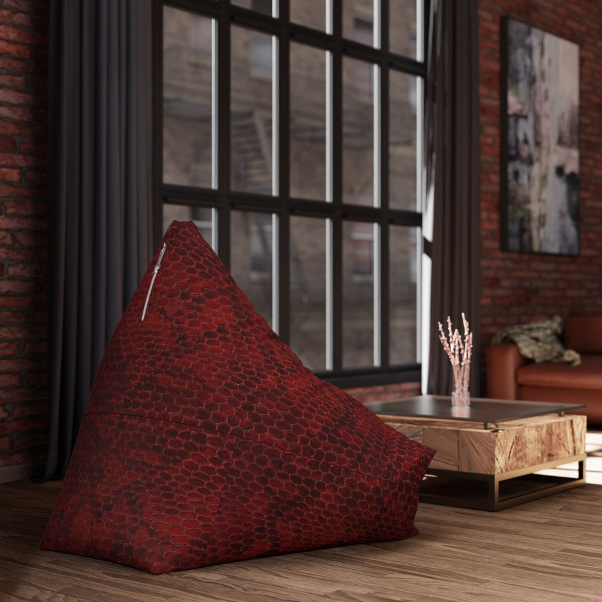 Red bean bag chair in a room with large windows and a brick wall.