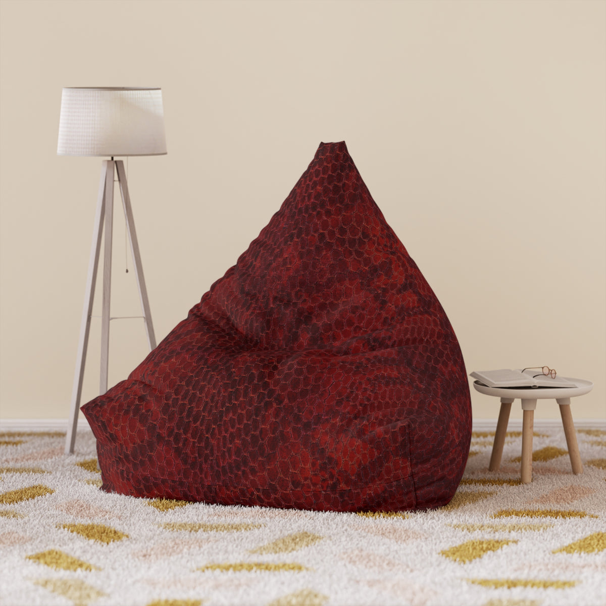 Red bean bag chair in a room with a lamp and small table.